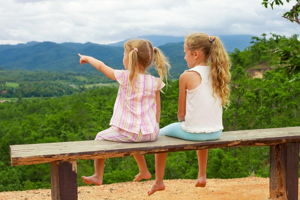 two little girls point at the horizon